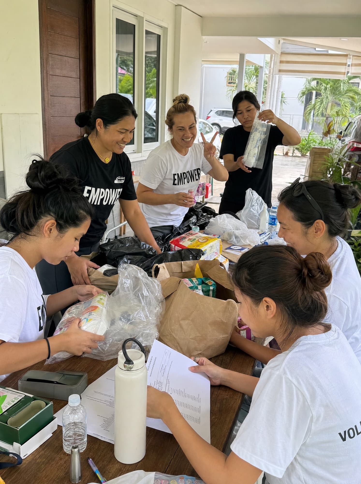 Volunteers in Empower shirts working together to sort and pack supplies